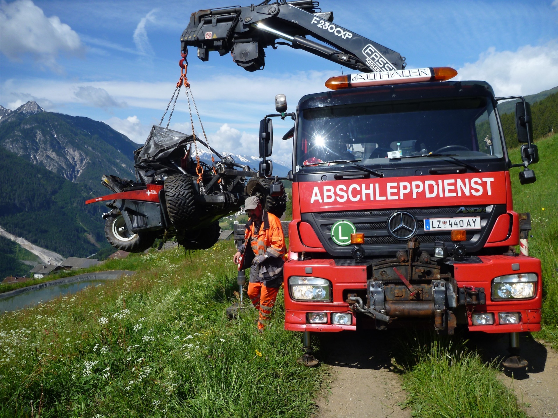 Ein Traktor wird von einem LKW aus dem Feld gehoben